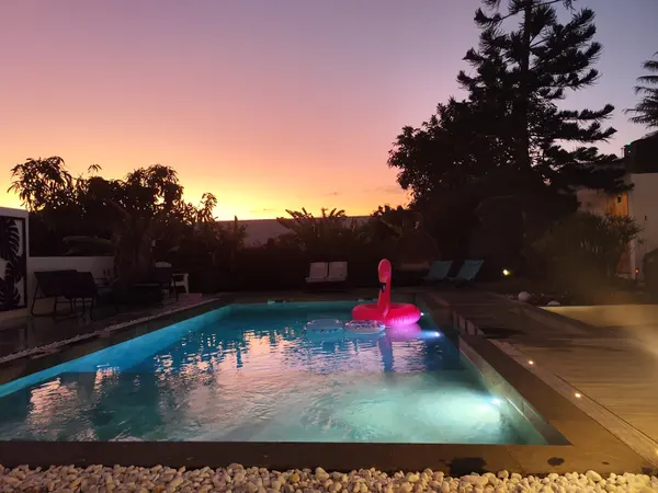 La piscine éclairée sous le ciel rose du coucher de soleil